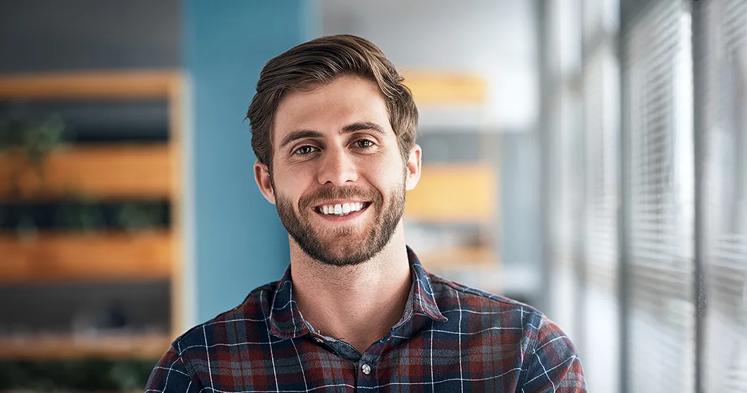 Jeune designer souriant dans un bureau
